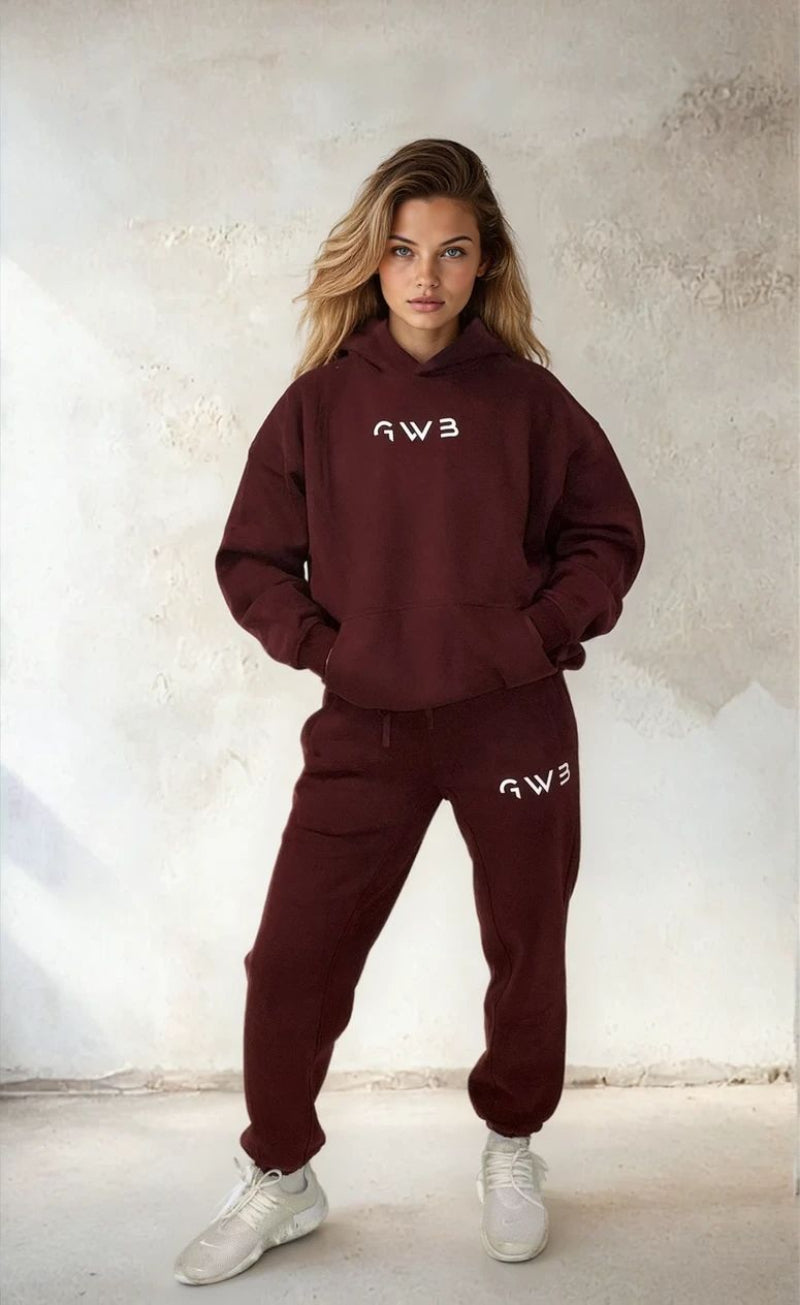 Person wearing a burgundy hoodie and pants with 'G3' logo against a light background